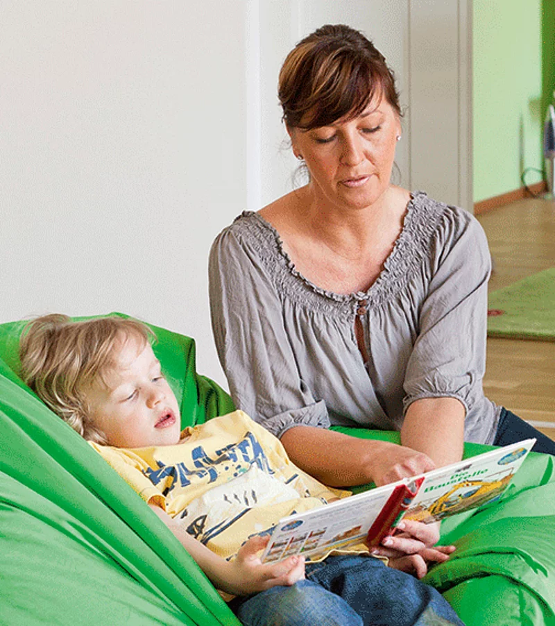 Frau, die ein Kind ein Buch vorliest